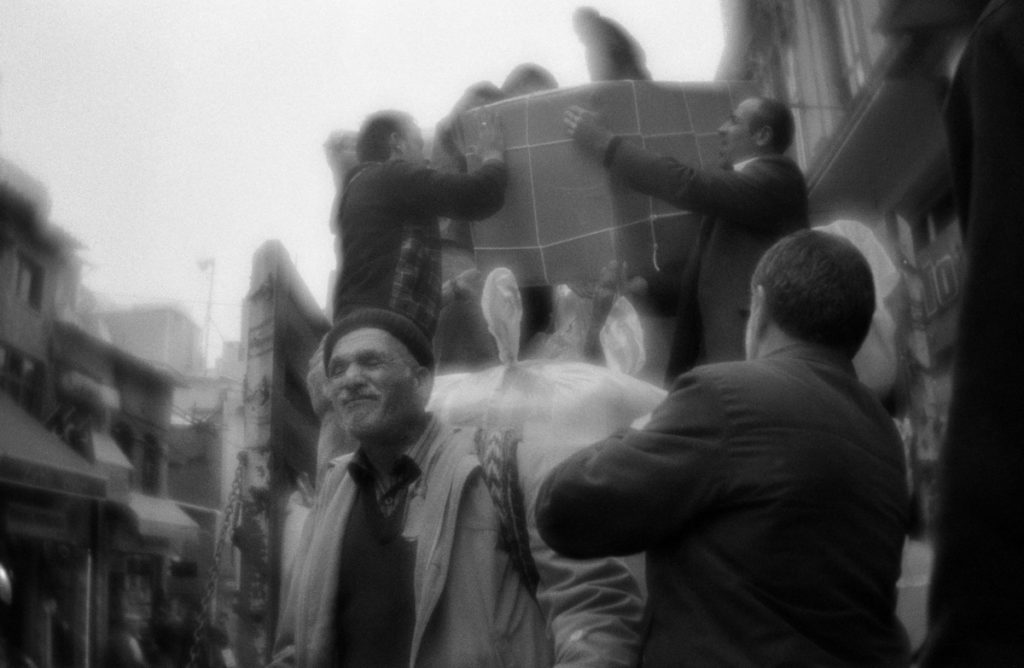 People help to the loader to unload at the market in Istanbul. T