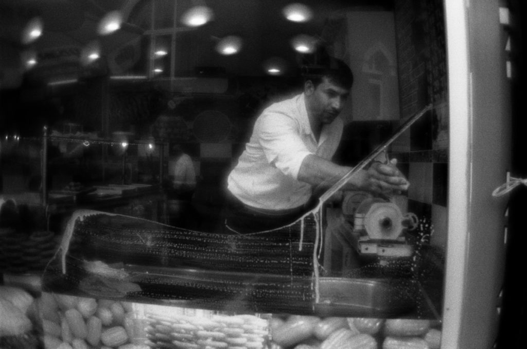 Man cleans the window of confectioner's shop. Fener district, Is