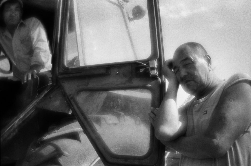 Tractor drivers wait for the ferry across the Akhtuba river 