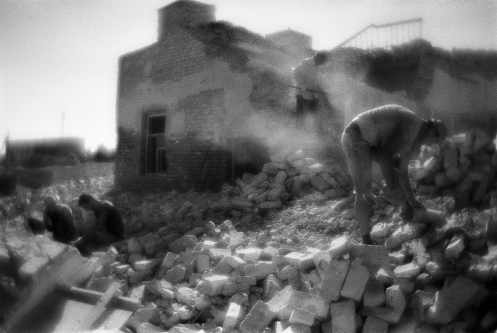 Workers dismantle the former evening school on the bricks.