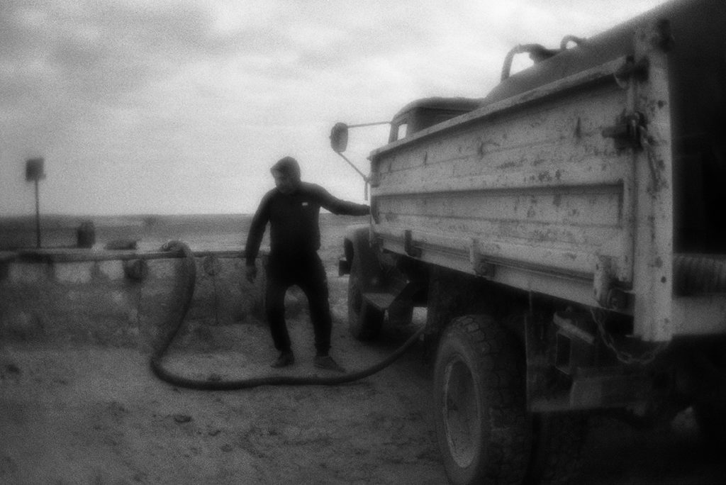 Water carrier draws water from the well to deliver it to locals.